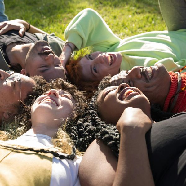 A diverse group of people smiling and relaxing after a yoga session.